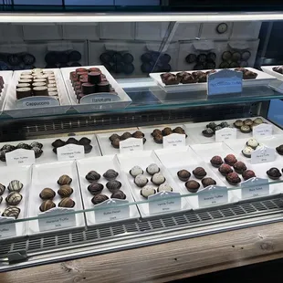 The bakery now sells chocolates. I wonder if a piece cost more than $10?