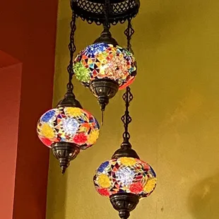 three colorful mosaic lamps hanging from the ceiling