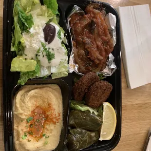 Vegetable plate with feta salad, hummus, dolmas, eggplant moussaka, and falafel.