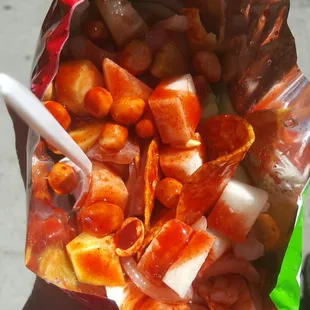 Tostilocos! Chips, pickled pig skins, cucumber, jicama, japanese peanuts drowned in chamoy sauce and lemon juice