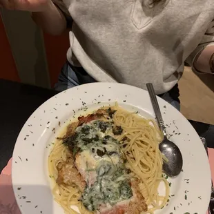 a plate of pasta with chicken and spinach