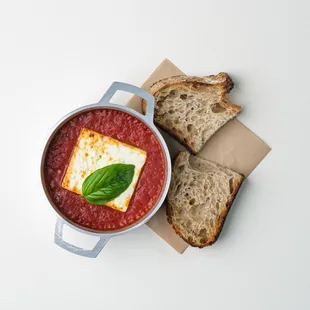 a bowl of tomato soup with bread
