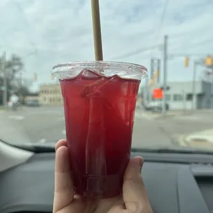 a hand holding a plastic cup with a straw