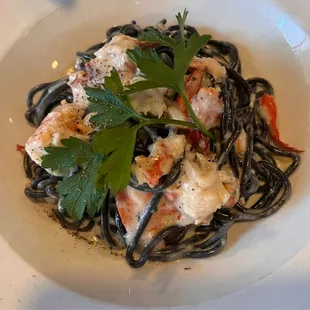 a plate of pasta with shrimp and vegetables