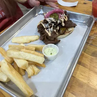 a tray of fries and a steak sandwich
