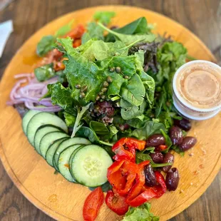 a wooden plate with a salad on it