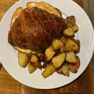 Sausage, egg, and cheese croissant with potatoes
