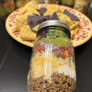 a jar of taco salad and a plate of tortillas