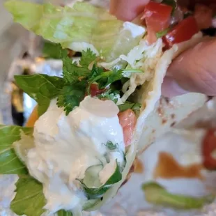 a hand holding a burrito