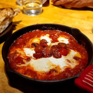 Shakshuka - eggs, harissa tomato sauce, calabrian sausage, cucumber onion salad, feta &amp; toasted bread