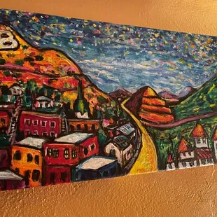 a painting of a town on a wall