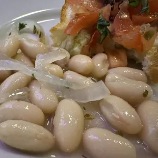 Two appetizers -- white beans, and bruschetta.