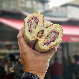 a person holding a sandwich in their hand