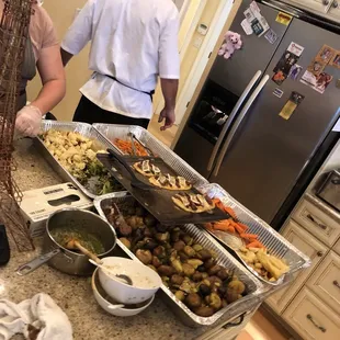 a man and woman preparing a buffet