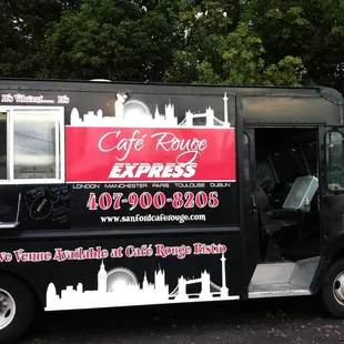 a black food truck parked in a parking lot
