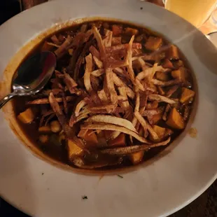 a bowl of soup and a glass of orange juice