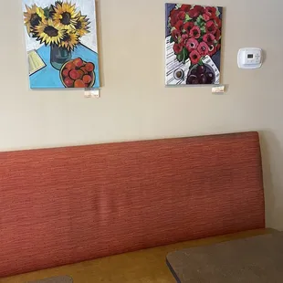 a red bench with a vase of sunflowers