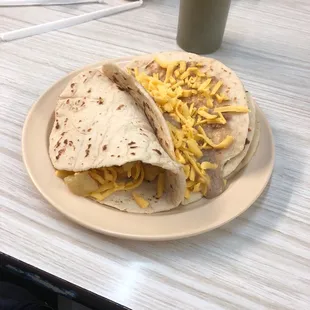 two burritos with cheese on them