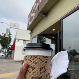a hand holding a coffee cup