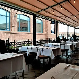 Notice the glowing lights overhead, and the thriving succulent planters at your elbows by the railing? The fresh tablecloths and silverware.