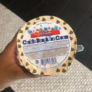 a person holding a container of ice cream