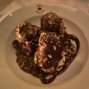 a plate of desserts with chocolate sauce and nuts