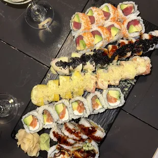 various types of sushi on a black plate