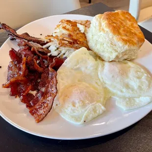 Eggs and bacon sampler with haystack potatoes and a biscuit