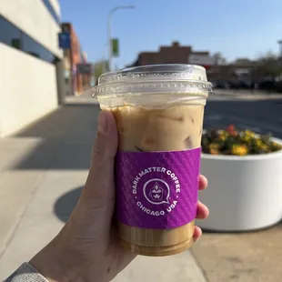 a hand holding a cup of iced coffee