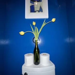a vase of flowers on a toilet