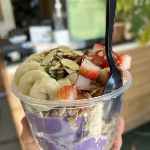  hand holding a bowl of fruit and yogurt