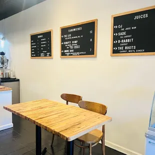 a table and chairs with menus on the wall