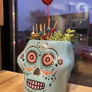 a sugar skull planter on a table