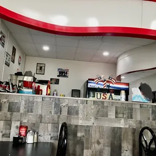 The swoosh above the server&apos;s area replicates the waving of the American Flag  Tables for two nestle against this half wall.