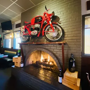 a red motorcycle on top of a fireplace