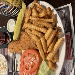 Fish sandwich with lettuce and tomato and fries