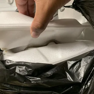 a person putting a napkin in a black bag