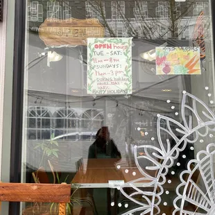 a woman sitting at a table in front of a window