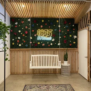 a wooden bench in front of a floral wall