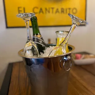 two champagne flutes in a bucket of ice