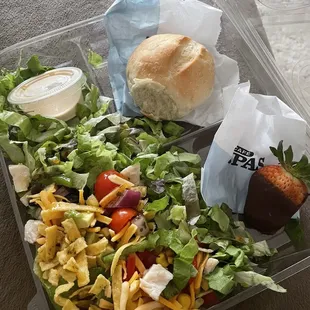 a salad and a sandwich in a plastic container