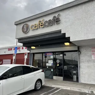 a white car parked in front of a cafe