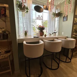 a row of white chairs in front of a window