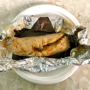 a plate of food wrapped in foil