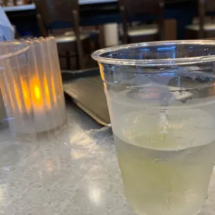 a glass of lemonade with ice on a table