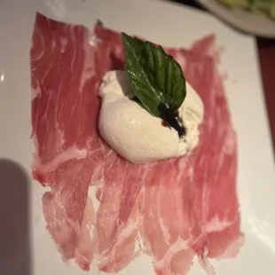 a piece of meat with a leaf on top