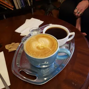 two cups of coffee on a tray