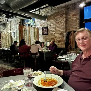 a man sitting at a table with a plate of food