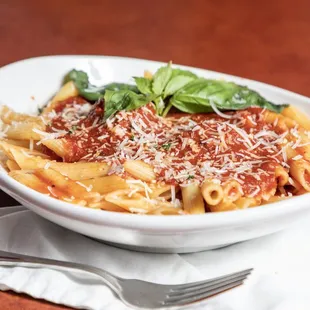 a bowl of pasta with spinach and parmesan cheese