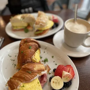a croissant sandwich and a cup of coffee